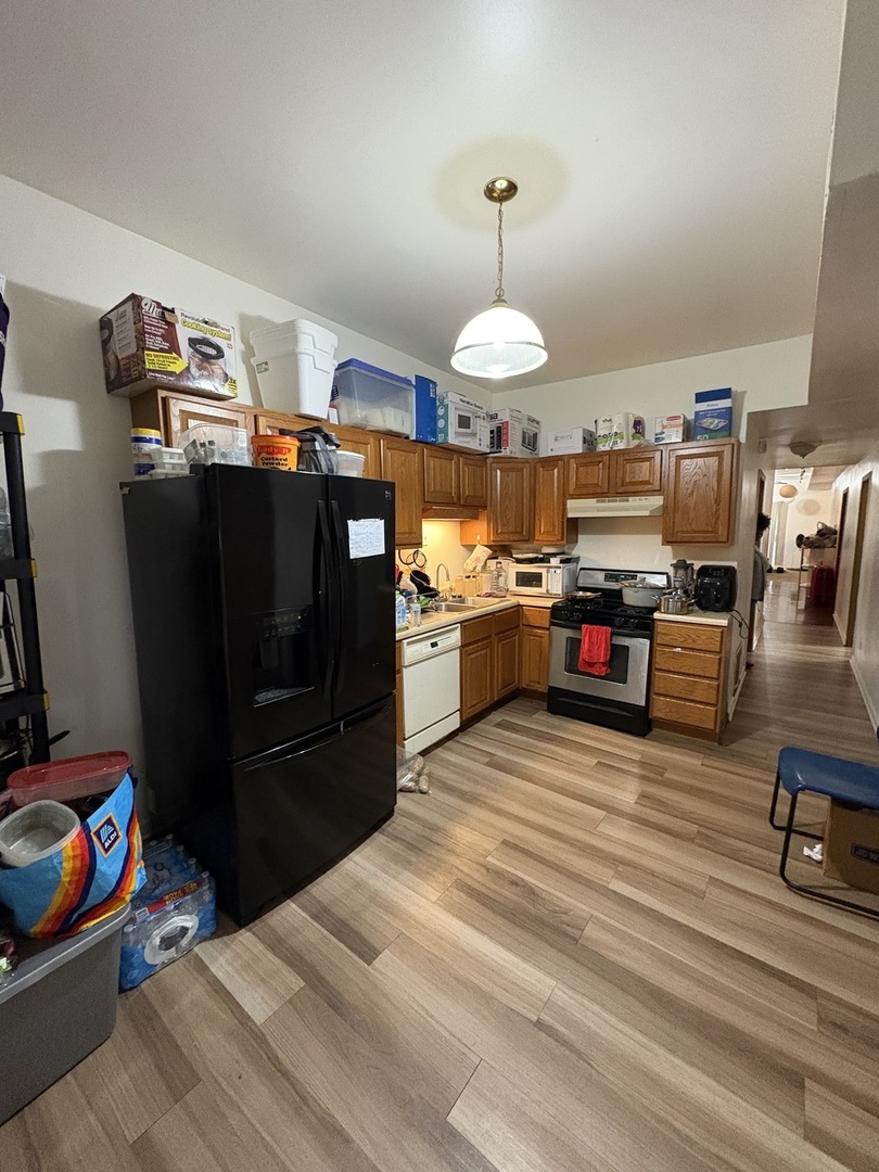 8729 South Commercial Avenue Chicago, IL 60617 - Photo 5 of 17 a kitchen with stainless steel appliances kitchen island granite countertop a refrigerator and a stove