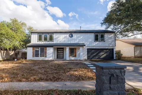 a front view of a house with yard garage and outdoor seating