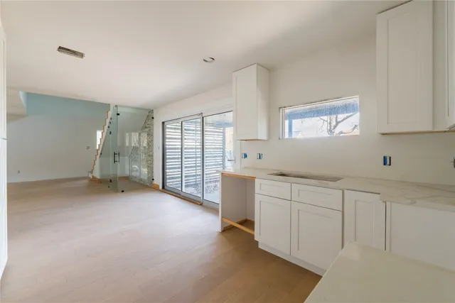 a kitchen with white cabinets and sink