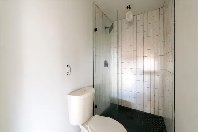 a bathroom with a toilet and a shower