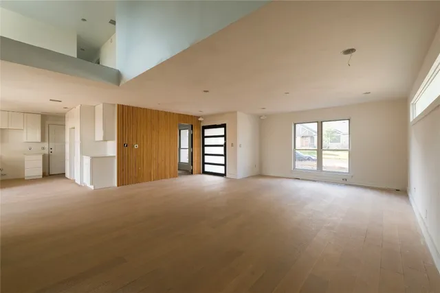 a view of empty room with windows and ceiling fan