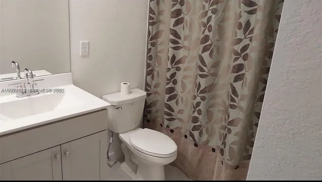 a white toilet sitting next to a white sink