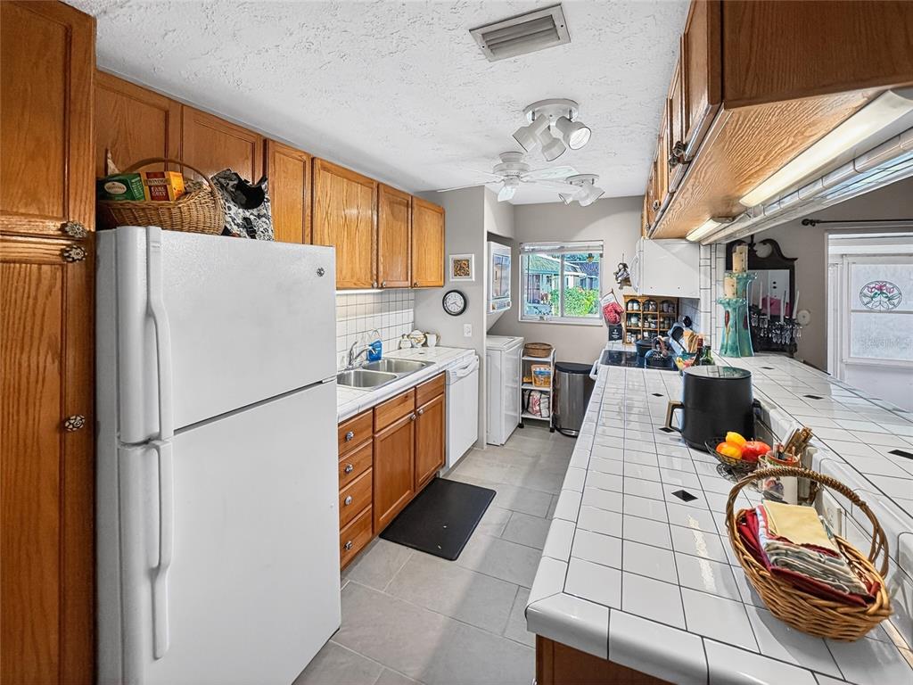 4160 Fruitville Road, Unit 11 Sarasota, FL 34232 - Photo 11 of 63 a kitchen with stainless steel appliances granite countertop a refrigerator a sink dishwasher a stove and a dining table with wooden floor