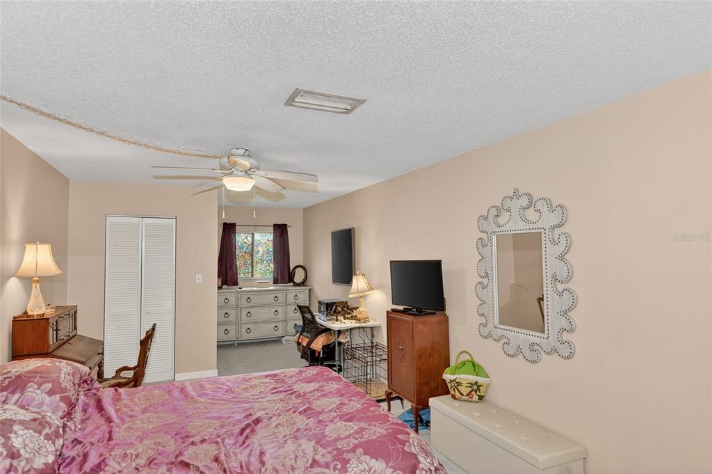 4160 Fruitville Road, Unit 11 Sarasota, FL 34232 - Photo 17 of 63 a bedroom with a bed flat screen tv and couches
