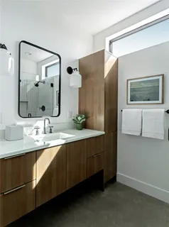 a bedroom with a bed and a lamp on dresser