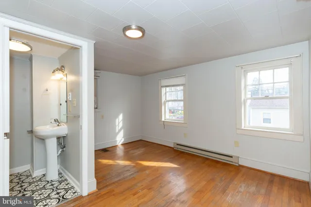 an empty room with wooden floor and a window