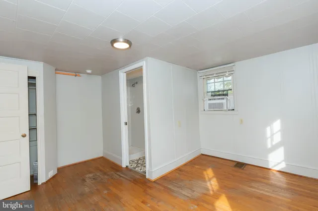 a view of an empty room and window and wooden floor
