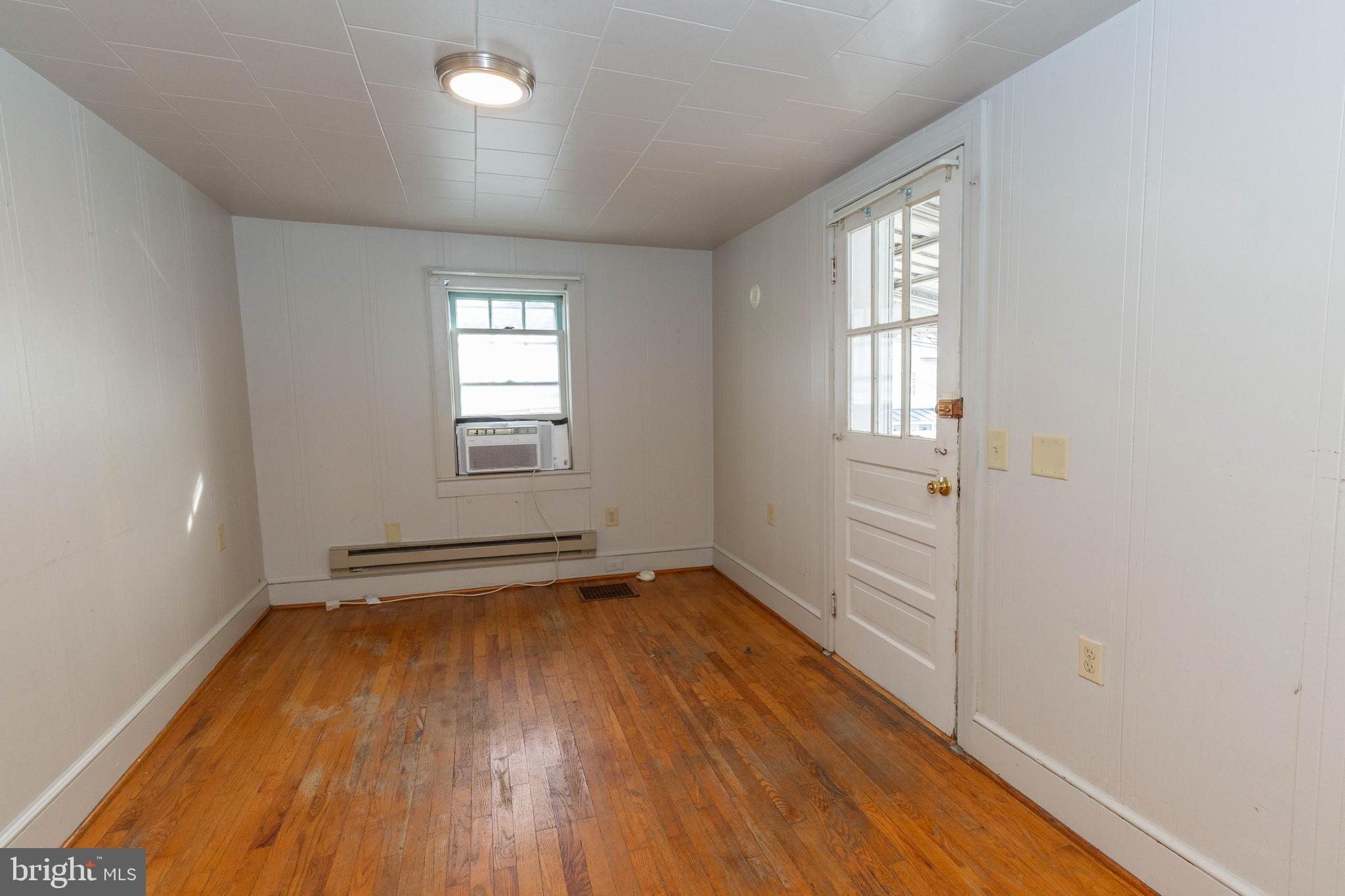 326 East Liberty Street, Unit 6 Charles Town, WV 25414 - Photo 5 of 17 an empty room with wooden floor and windows