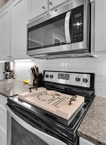 a stove top oven sitting inside of a kitchen