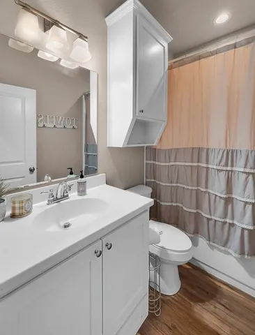 a bathroom with a sink a toilet a mirror and shower