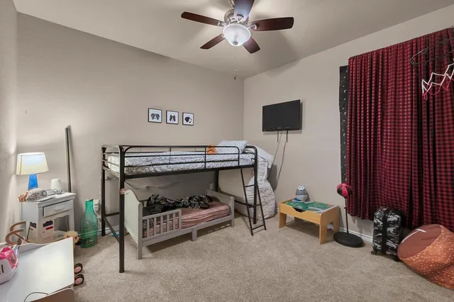 a bedroom with furniture and a fan