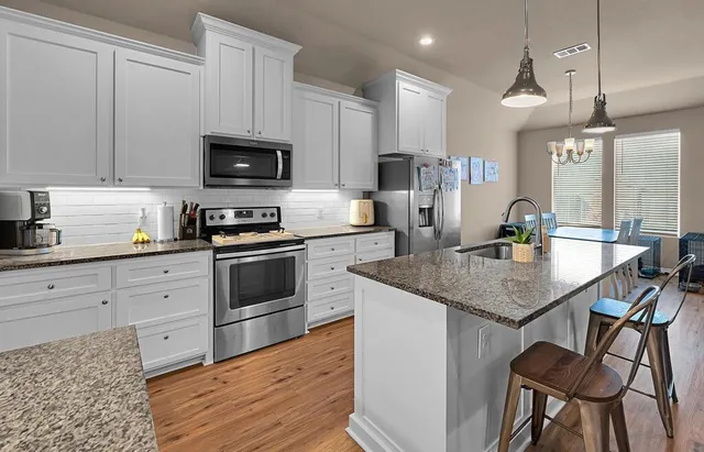 a kitchen with a stove a sink and a refrigerator