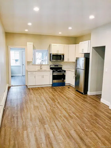 a kitchen with stainless steel appliances a refrigerator and a stove top oven