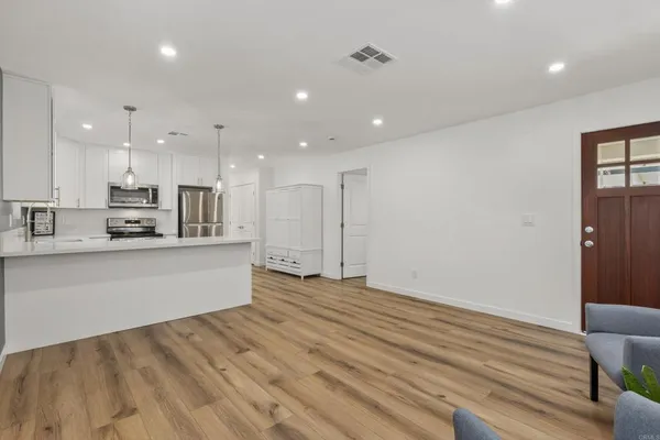 a large kitchen with stainless steel appliances kitchen island a large counter top and a stove top oven