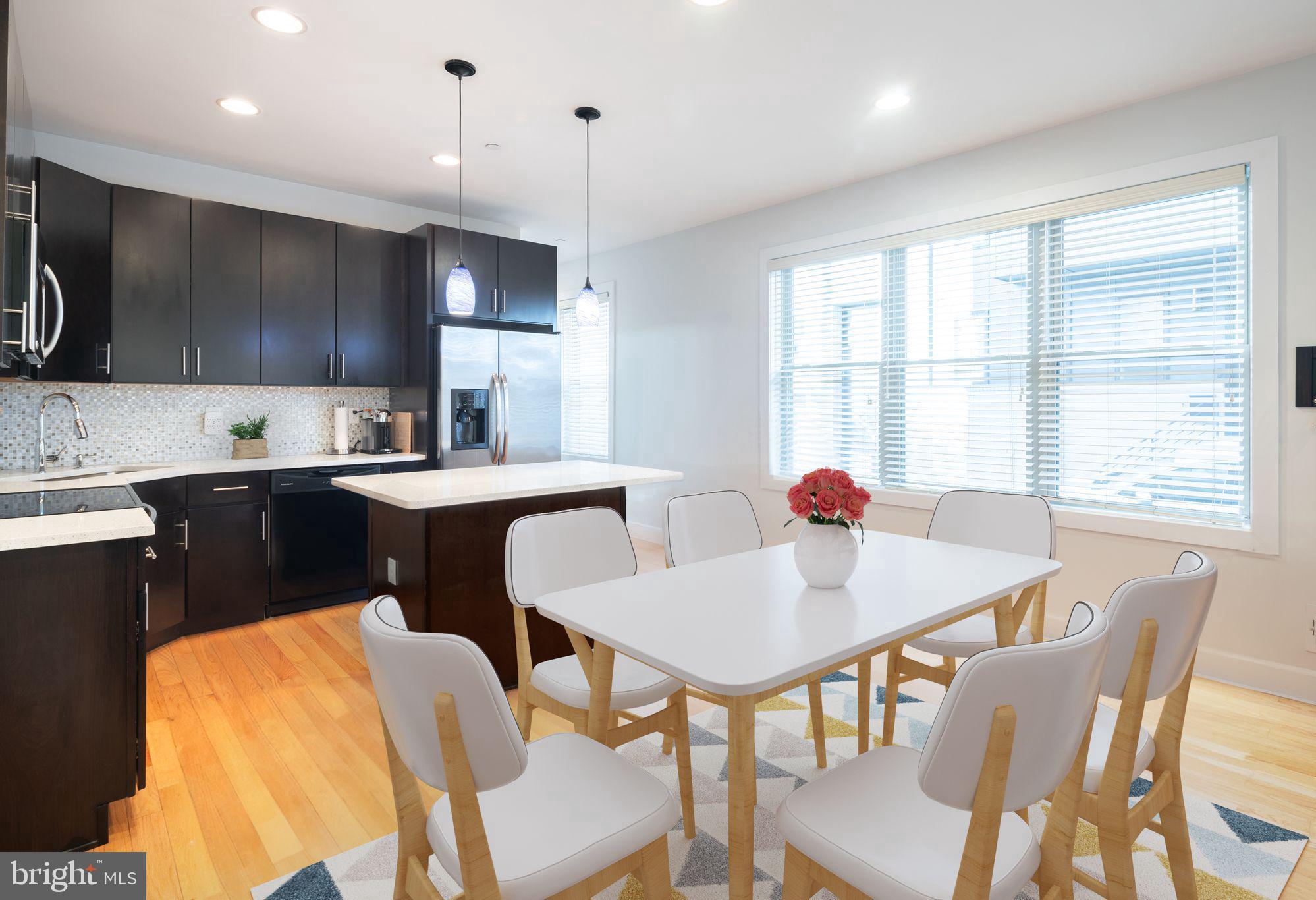a kitchen with a dining table chairs and sink