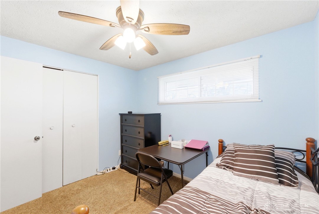 5171 Fishburg Road Dayton, OH 45424 - Photo 22 of 35 This cozy bedroom features warm carpeting, convenient closet space, and a bright window with blinds.