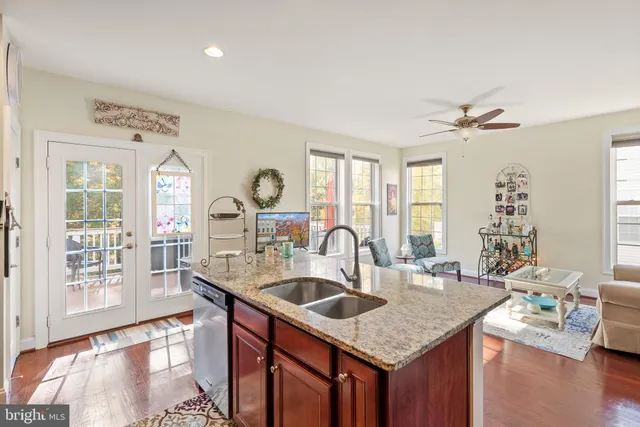 a kitchen with a stove a sink a dining table and chairs with wooden floor