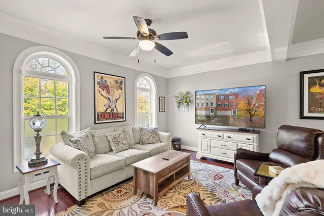 a living room with furniture a flat screen tv and a window