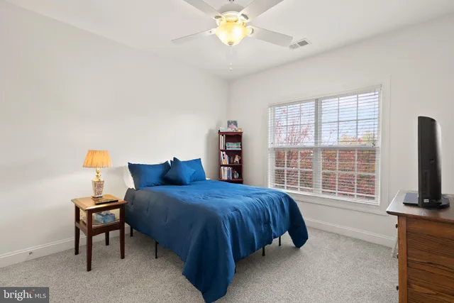 a bedroom with a bed and a flat tv screen on a dresser