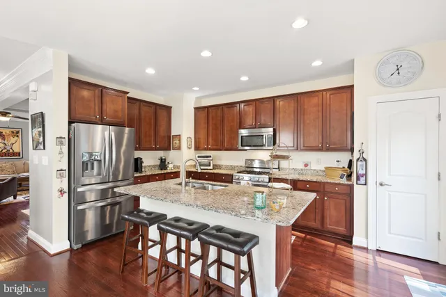 a kitchen with a refrigerator a stove top oven a sink and cabinets