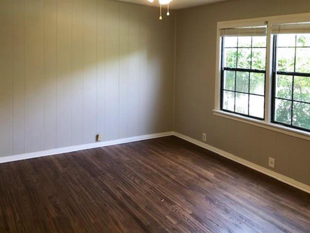 602 West 3rd Street Justin, TX 76247 - Photo 9 of 22 Room featuring wood-finish flooring, white baseboards, and walls with a panel detail on one side