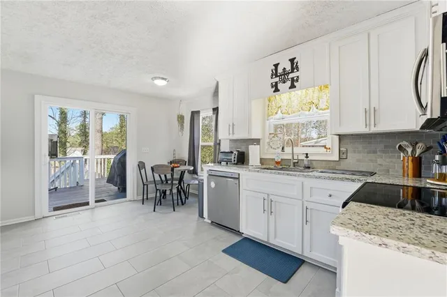 a kitchen with granite countertop white cabinets and white appliances