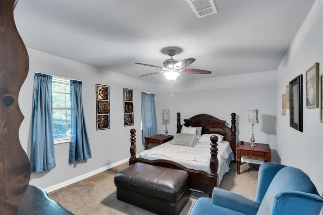 a bedroom with a bed a chandelier and dresser