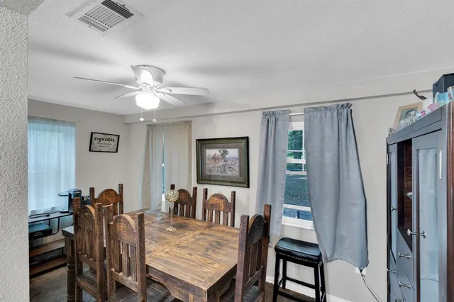 a kitchen with stainless steel appliances granite countertop a sink a stove a refrigerator cabinets and chairs