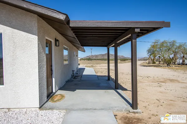 a kitchen with stainless steel appliances granite countertop a sink a stove a refrigerator and a dining table with wooden floor
