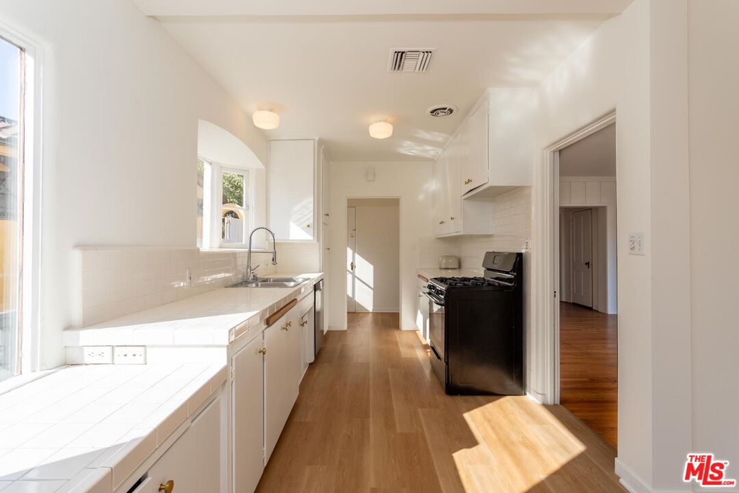 3936 Roderick Road Los Angeles, CA 90065 - Photo 14 of 36 a large kitchen with a lot of counter space and wooden floor