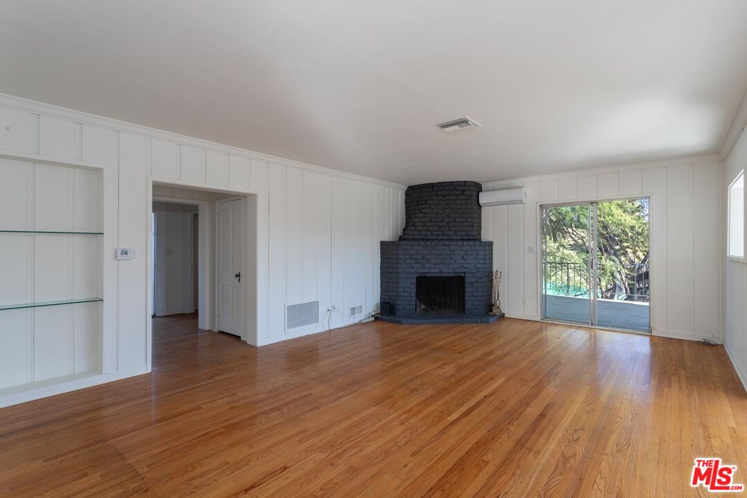 3936 Roderick Road Los Angeles, CA 90065 - Photo 6 of 36 a view of empty room with wooden floor and fireplace