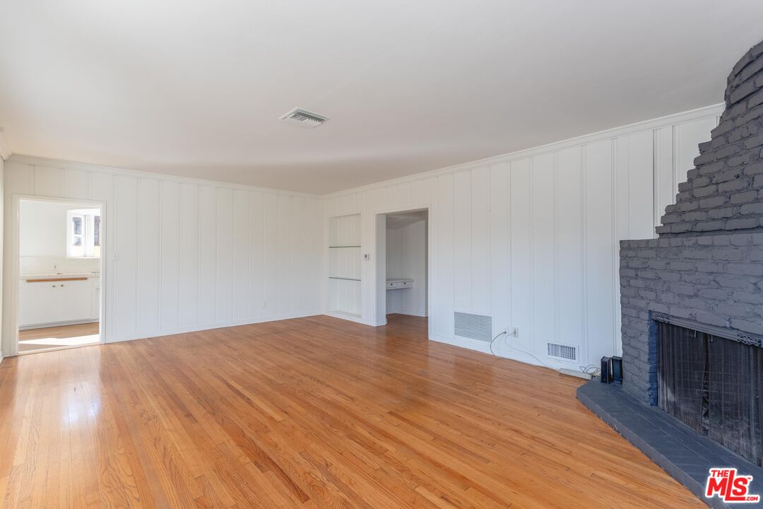 3936 Roderick Road Los Angeles, CA 90065 - Photo 7 of 36 a view of an empty room with wooden floor and a fireplace