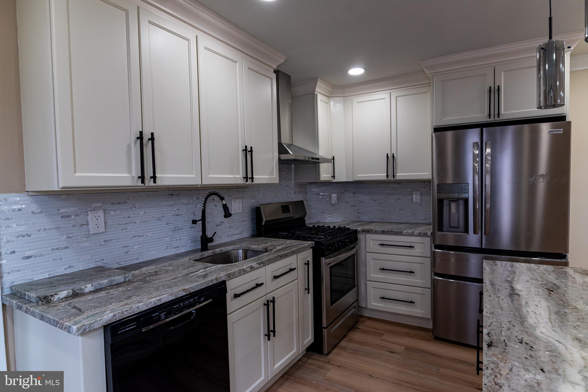 8030 Ferndale Street Philadelphia, PA 19111 - Photo 11 of 36 a kitchen with stainless steel appliances granite countertop a stove refrigerator and cabinets