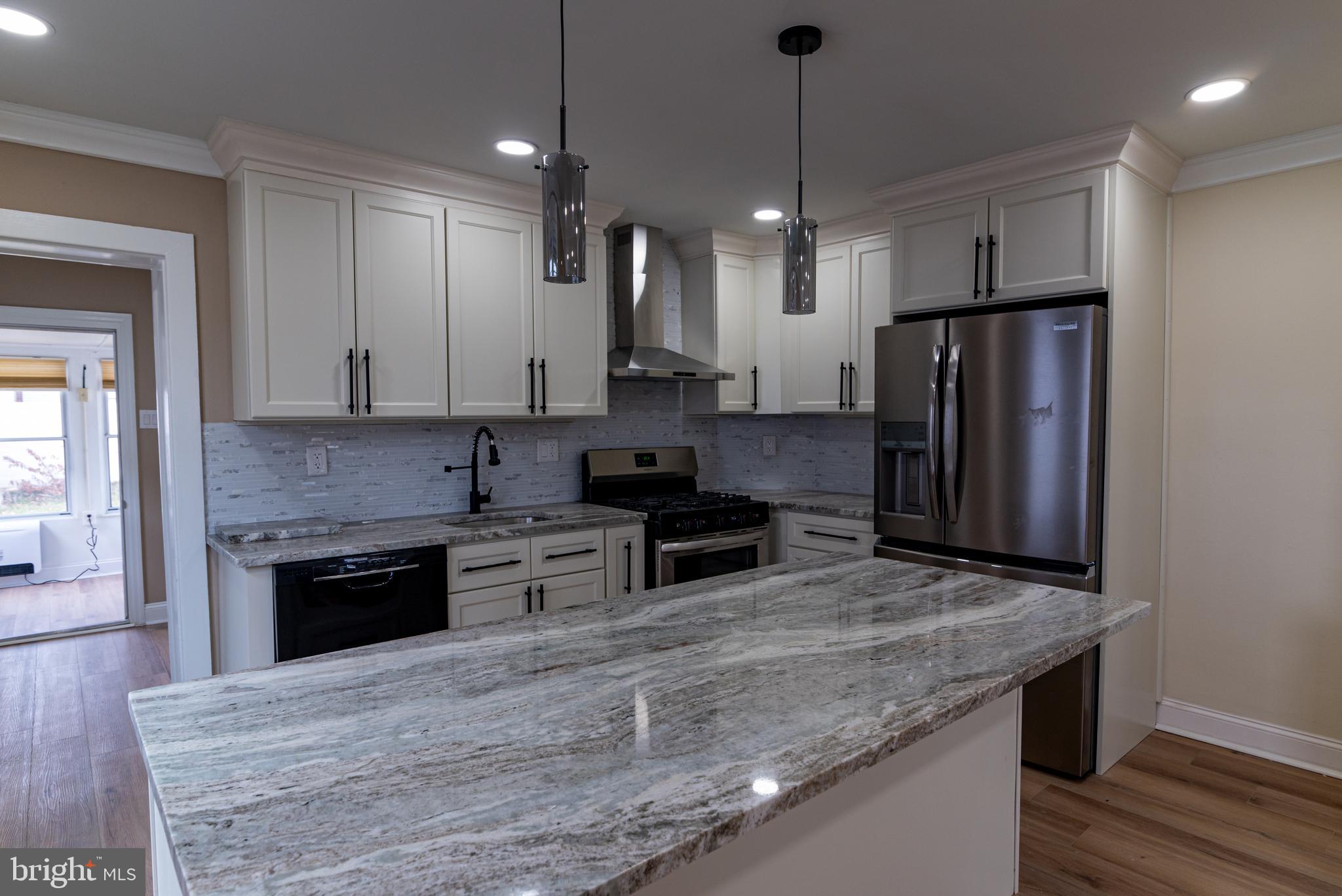8030 Ferndale Street Philadelphia, PA 19111 - Photo 10 of 36 a kitchen with stainless steel appliances granite countertop a stove refrigerator and cabinets