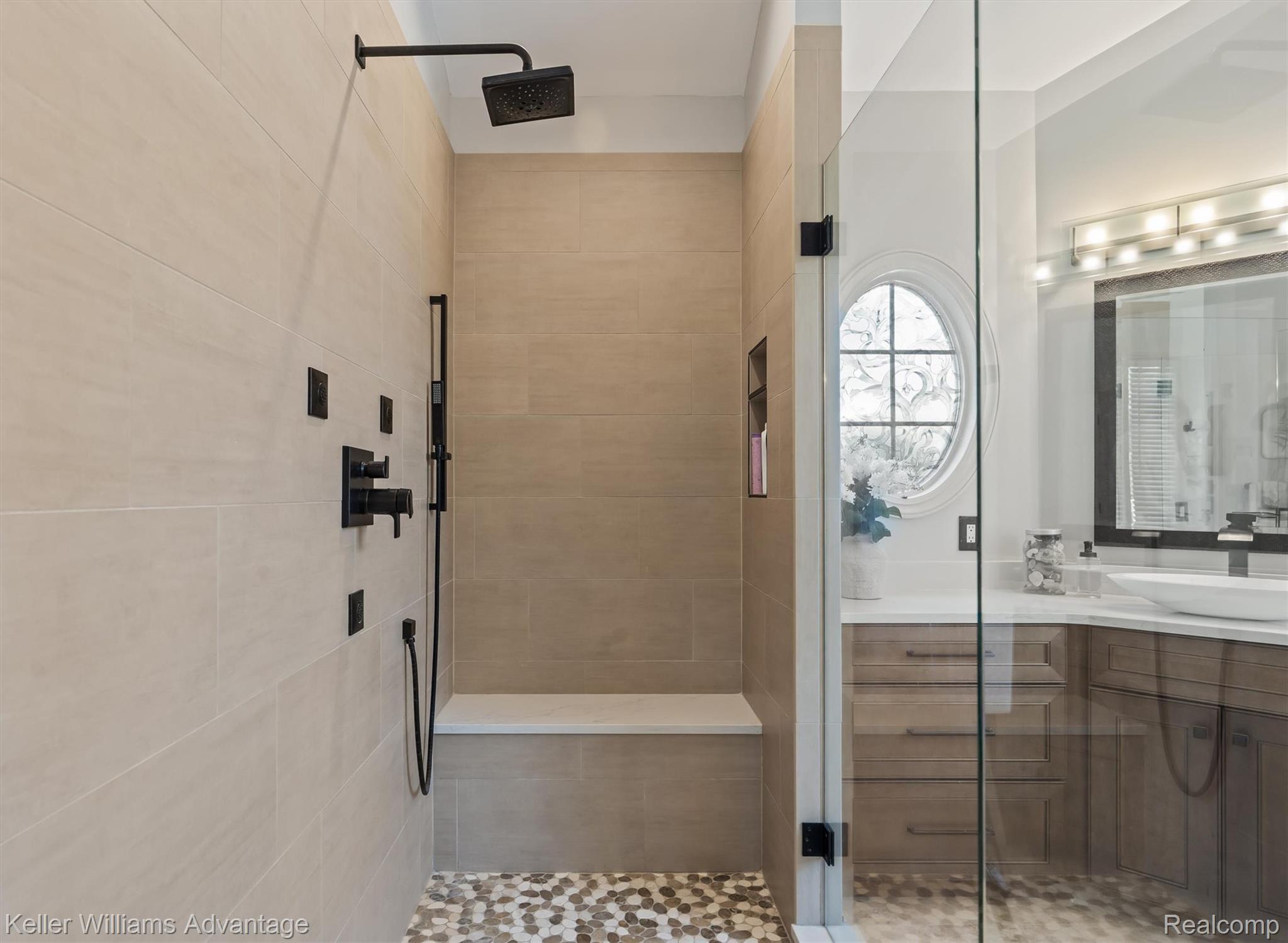 22878 Tree Top Court South Lyon, MI 48178 - Photo 22 of 75 Walk-in shower with large format tile walls, a built-in bench, and a rain showerhead