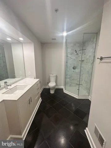 a spacious bathroom with a granite countertop sink a toilet and shower