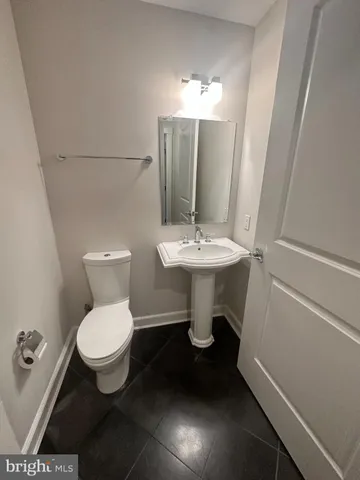 a white toilet sitting next to a bathroom sink