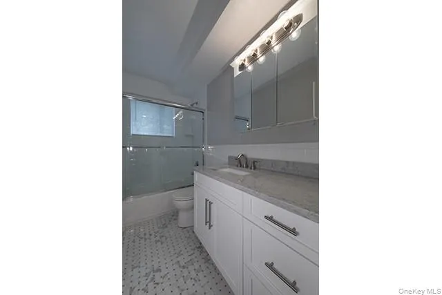 a bathroom with a granite countertop sink and mirror