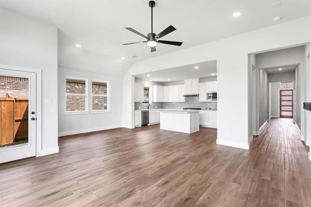 a view of a kitchen with wooden floor and a window