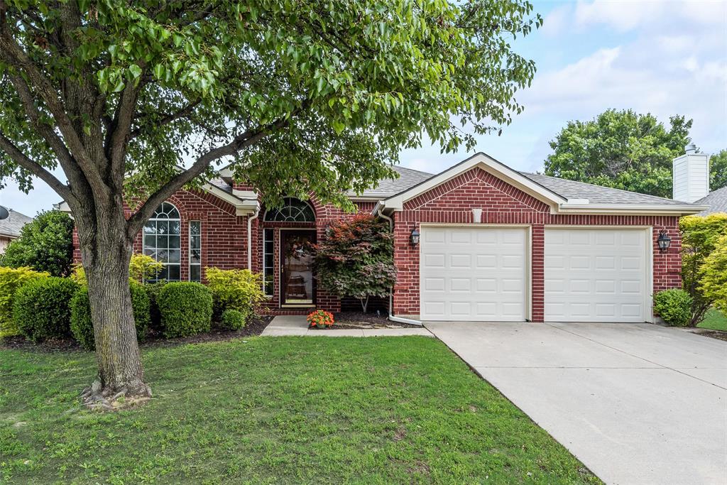 a front view of a house with a garden and yard