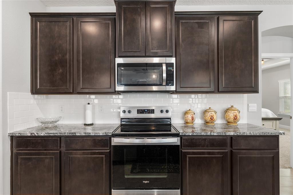 5912 Southwest 46th Drive Gainesville, FL 32608 - Photo 26 of 74 a kitchen with granite countertop stainless steel appliances and cabinets