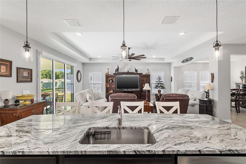5912 Southwest 46th Drive Gainesville, FL 32608 - Photo 29 of 74 a kitchen with kitchen island a sink stove and wooden floor