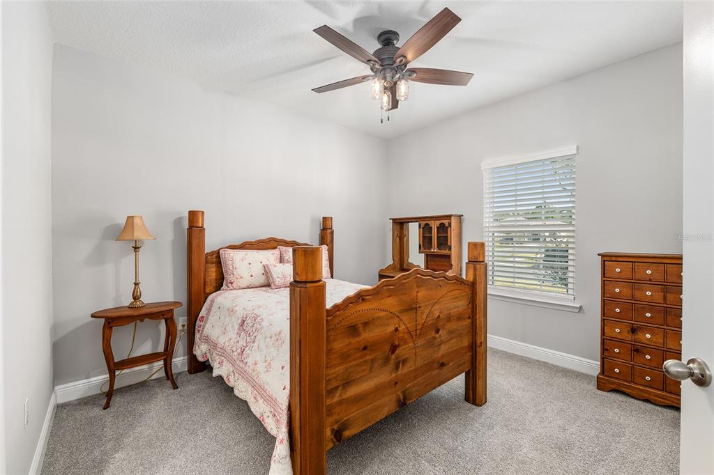 5912 Southwest 46th Drive Gainesville, FL 32608 - Photo 49 of 74 a bedroom with a bed a dresser and a chandelier