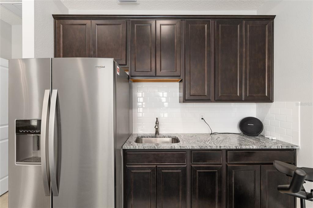 5912 Southwest 46th Drive Gainesville, FL 32608 - Photo 55 of 74 a kitchen with a sink a refrigerator and cabinets