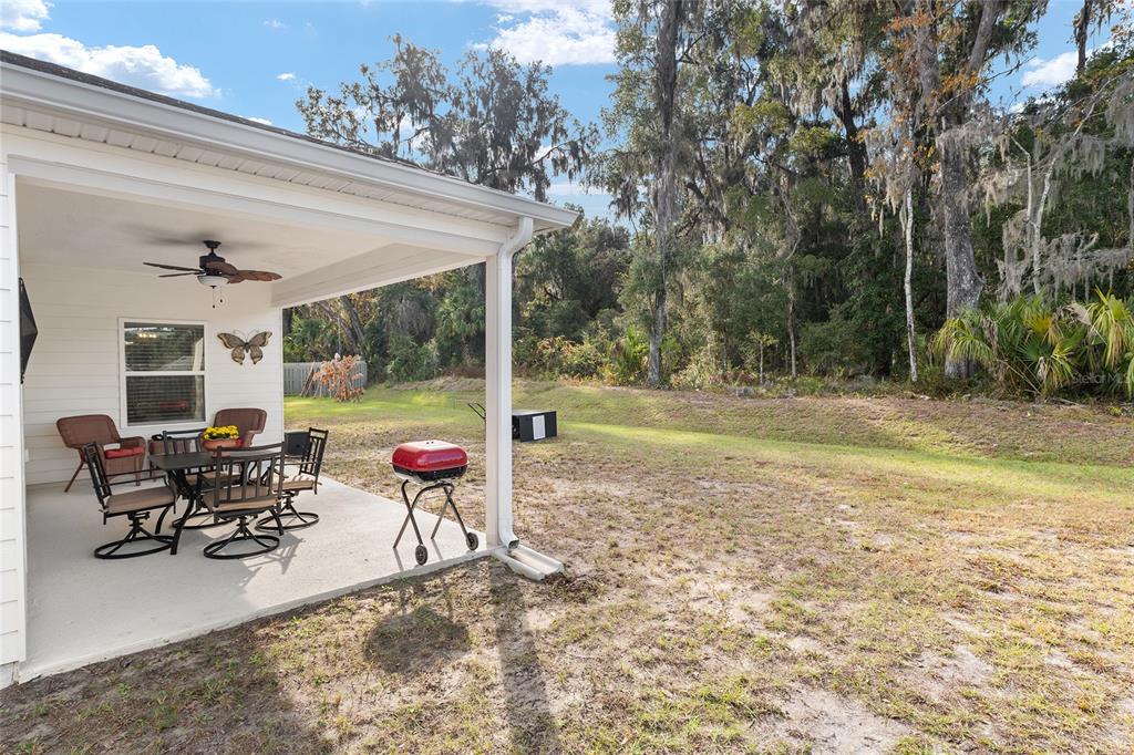 5912 Southwest 46th Drive Gainesville, FL 32608 - Photo 71 of 74 a view of a patio with table and chairs potted plants with wooden floor