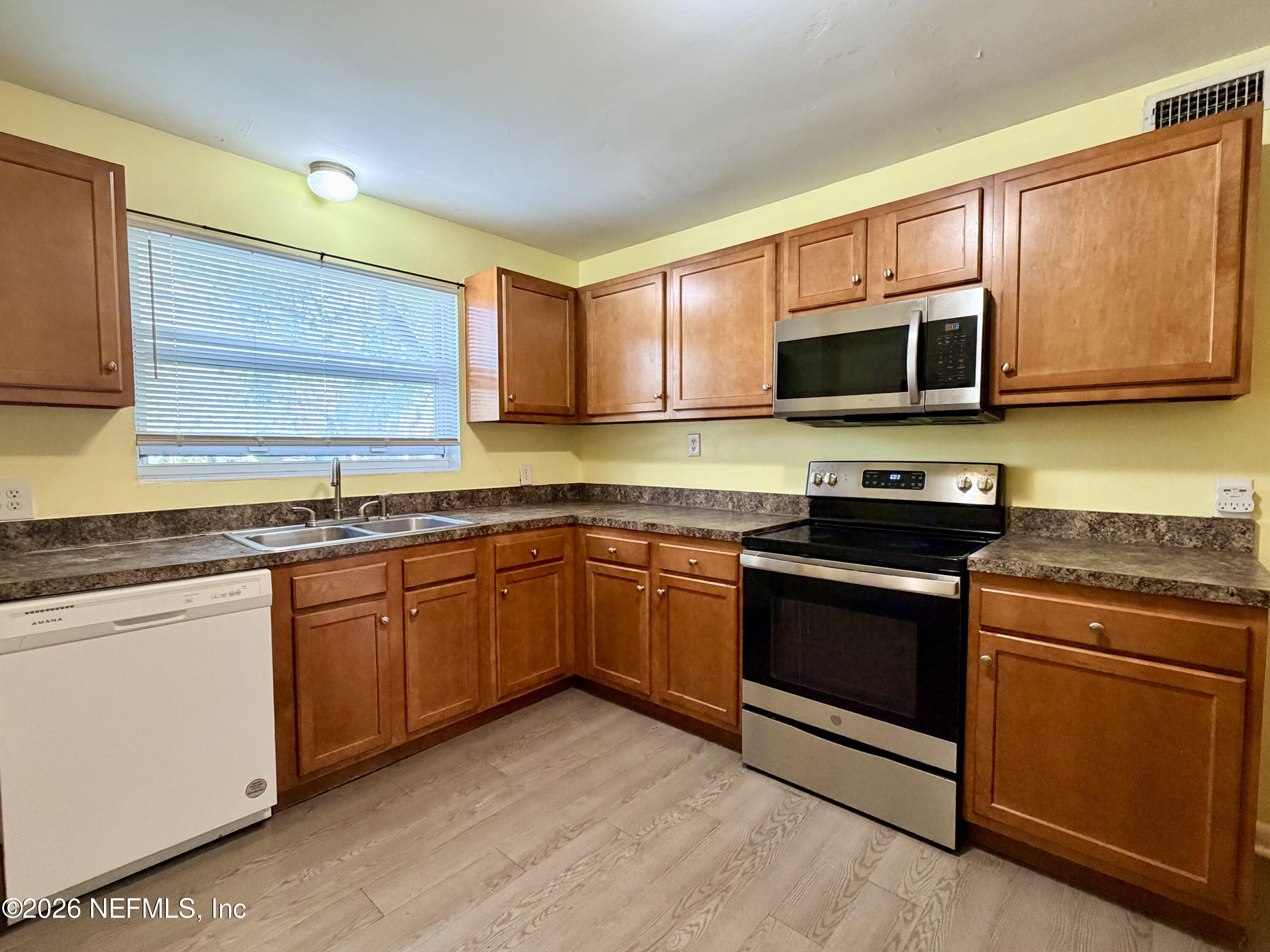 4037 Conga Street Jacksonville, FL 32217 - Photo 12 of 26 a kitchen with granite countertop wooden cabinets stainless steel appliances and a window