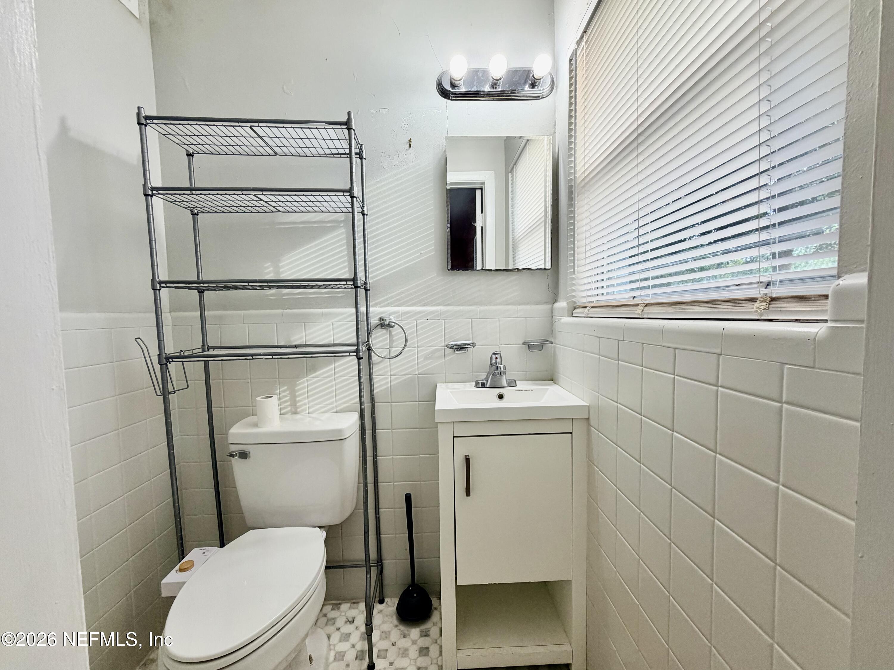 4037 Conga Street Jacksonville, FL 32217 - Photo 20 of 26 a bathroom with a toilet a sink and mirror