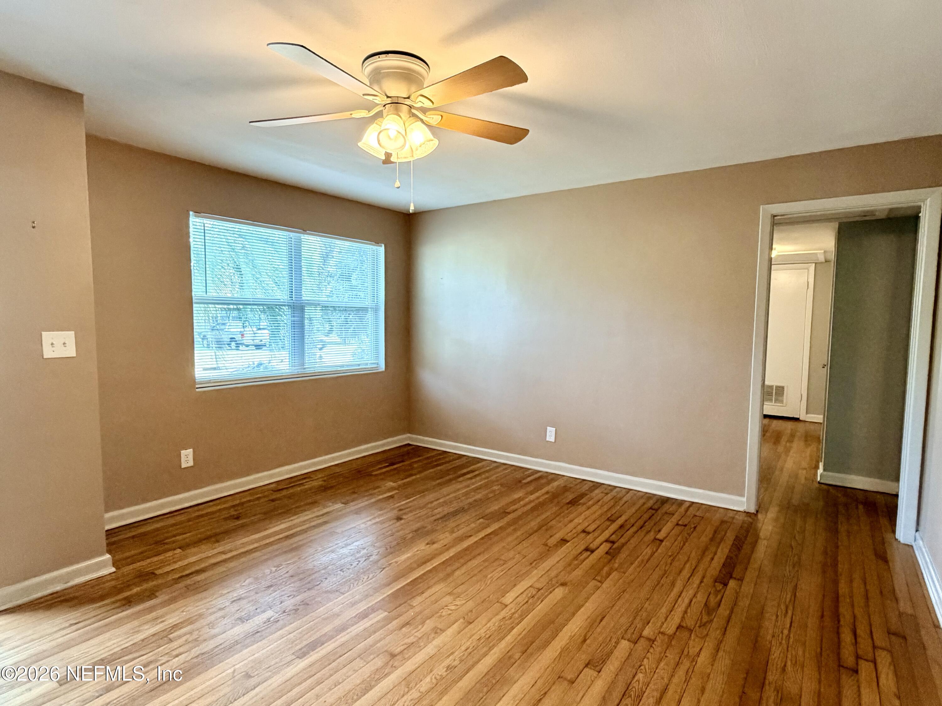 4037 Conga Street Jacksonville, FL 32217 - Photo 5 of 26 a view of an empty room with wooden floor and a window