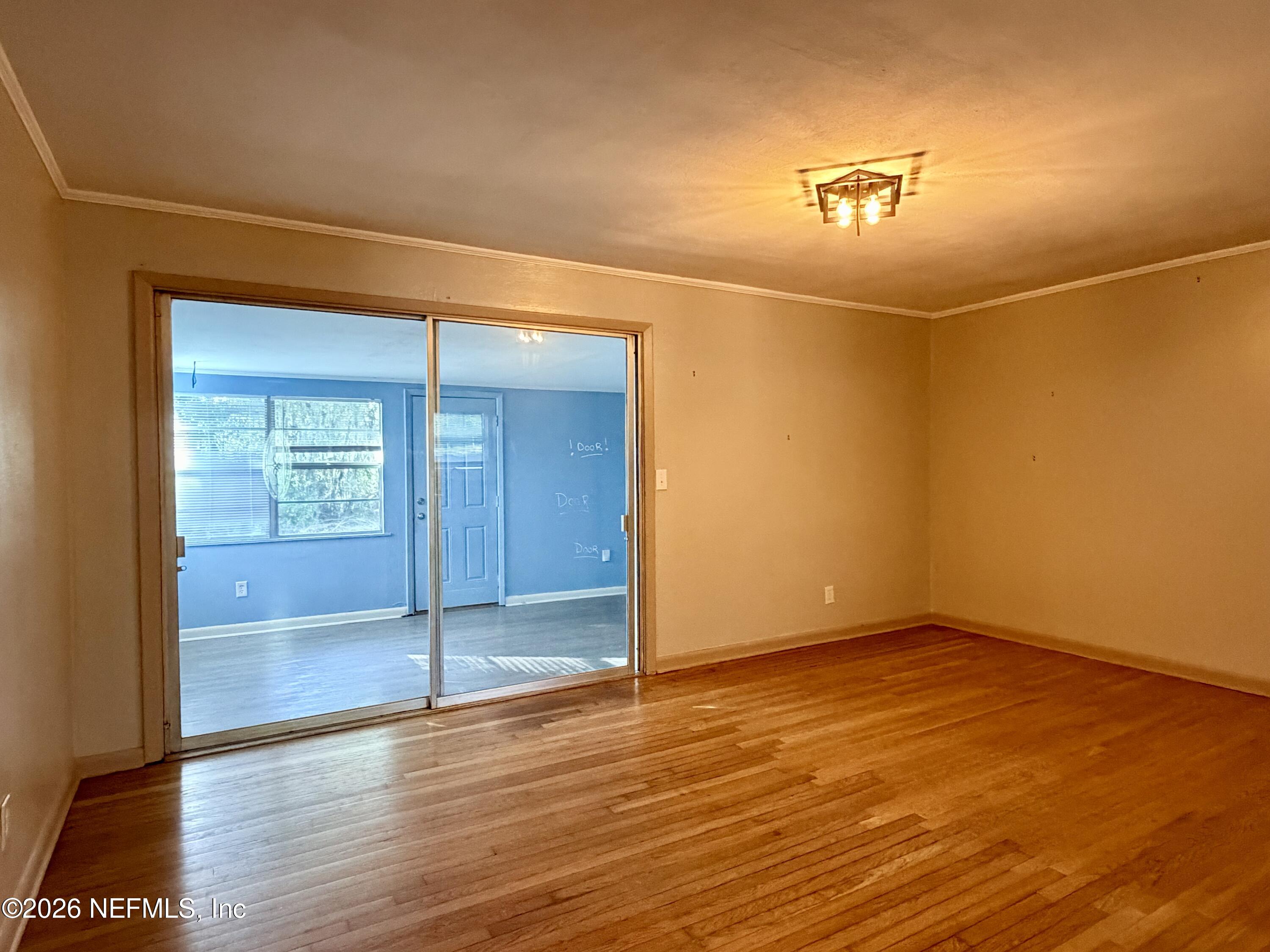 4037 Conga Street Jacksonville, FL 32217 - Photo 9 of 26 an empty room with wooden floor and door