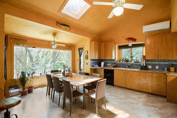 a kitchen with stainless steel appliances granite countertop table chairs stove and sink